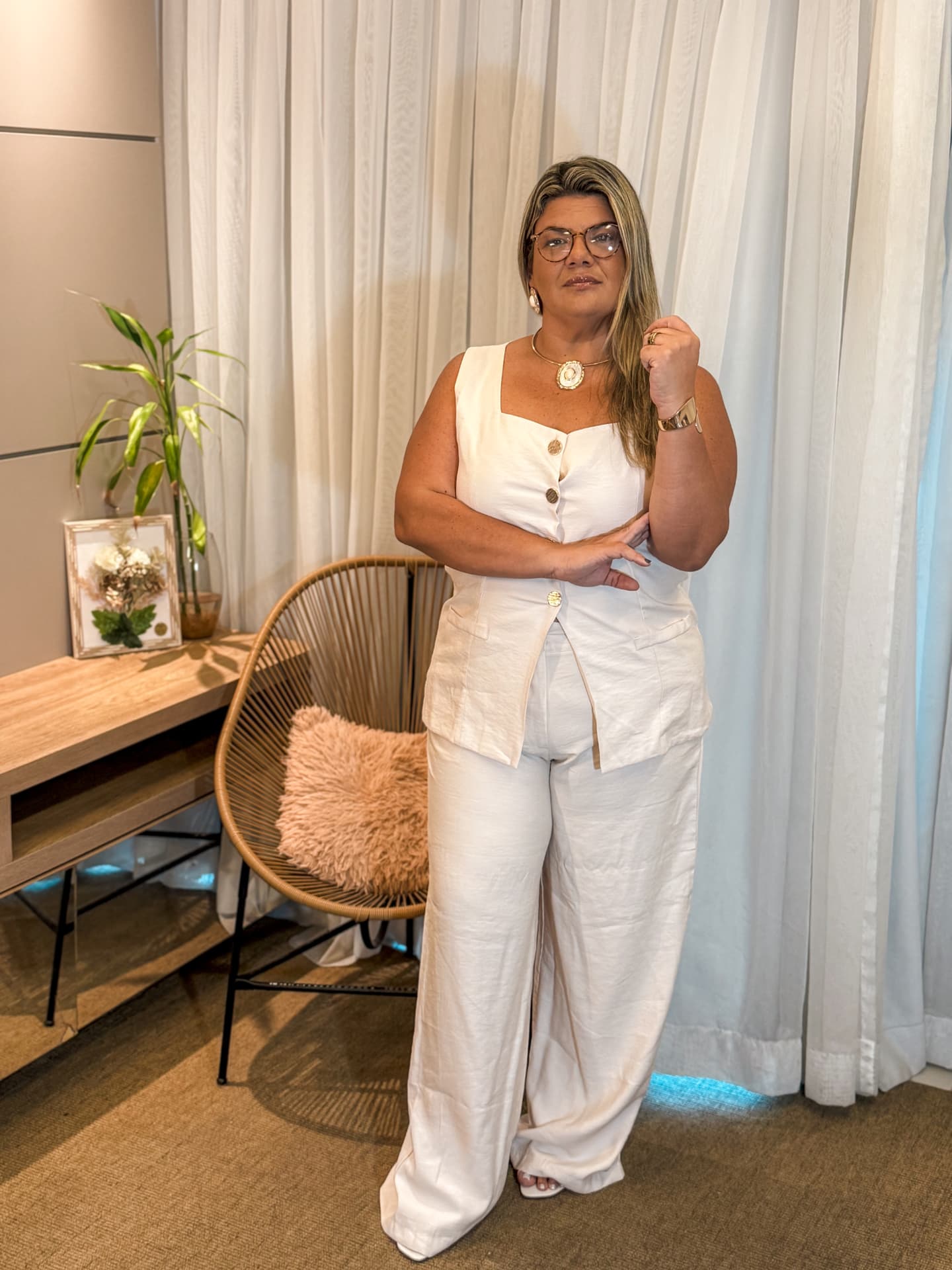 Thais Torres, psicanalista, em seu consultório com roupa branca e ambiente acolhedor